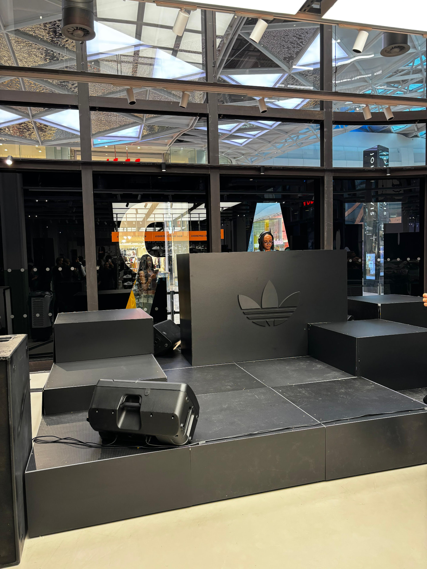 Black modular stage with DJ backdrop and wedge monitors