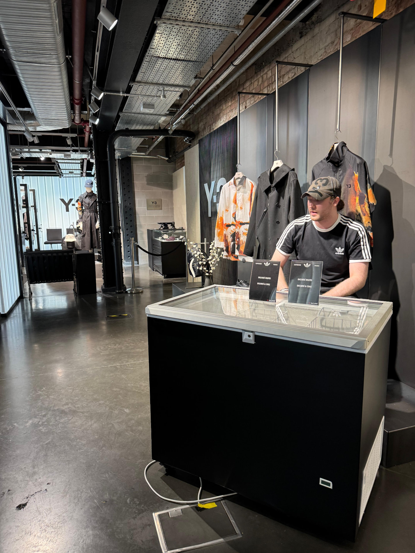 Black chest freezer drinks station staffed at a fashion store event