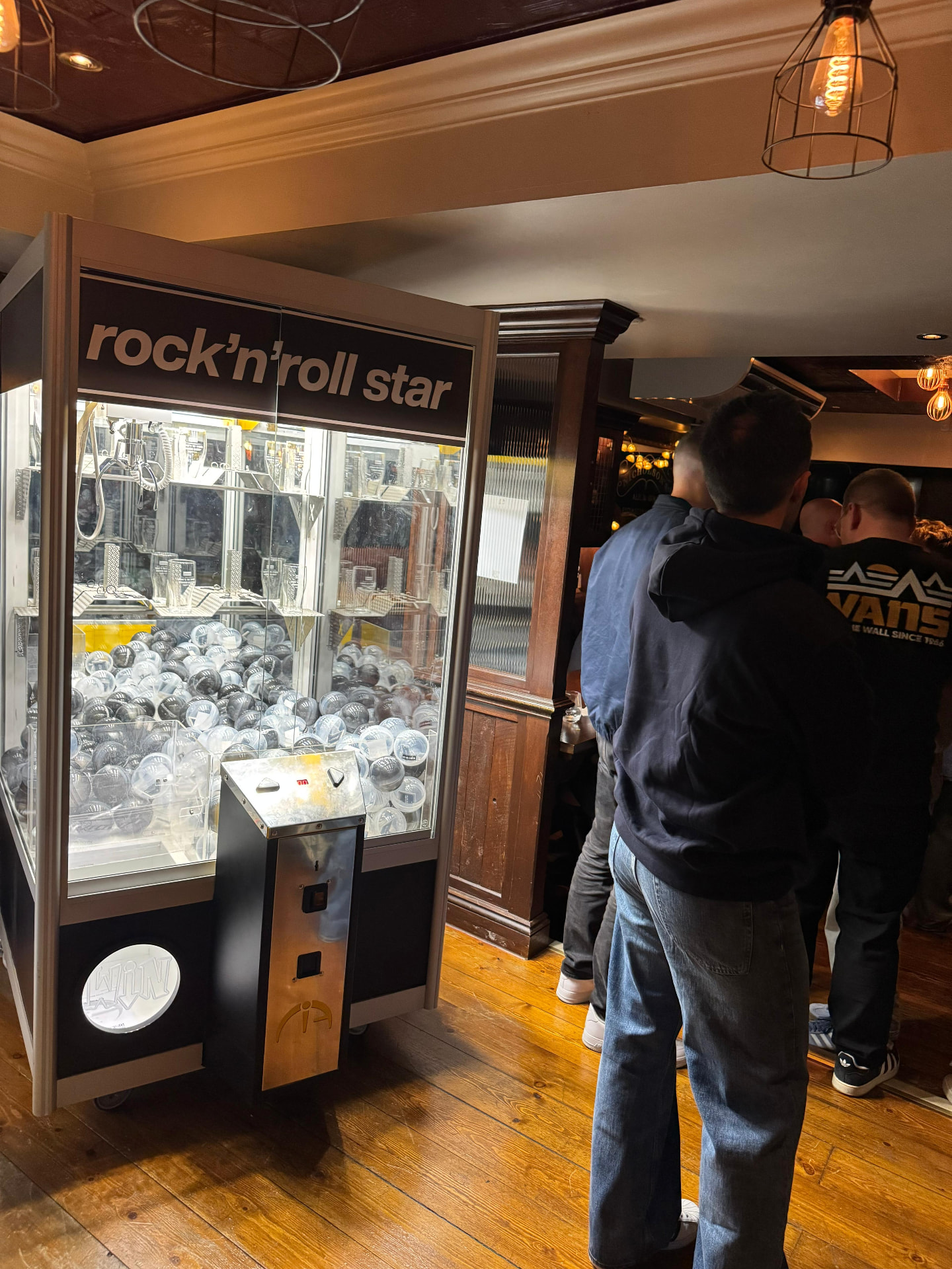 Guests playing a branded claw machine at an indoor activation